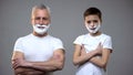 Happy senior male and little boy in shaving foam crossing hands on chest, fun