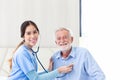 happy senior male patient health check and takecare by young female doctor or nurse at home after retirement for good health Royalty Free Stock Photo