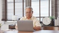 Happy Senior male using laptop searching for health insurance online website on laptop