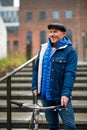 Happy senior man with bicycle outdoors in city, standing.