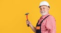 happy senior man carpenter in helmet on yellow background Royalty Free Stock Photo
