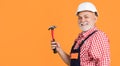 happy senior man carpenter in helmet on yellow background Royalty Free Stock Photo