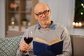 Happy senior man drinking wine and reading book Royalty Free Stock Photo