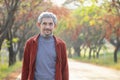 happy senior man enjoy in autumn by walking along the street in the park Royalty Free Stock Photo