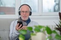 Senior man in headphones listening to music at home Royalty Free Stock Photo