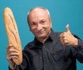 Happy senior man holding fresh baguette