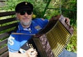 Happy senior man playing a melodeon