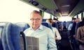 Happy senior man reading newspaper in travel bus Royalty Free Stock Photo