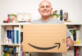 Happy Senior man smiling while holding new Amazon Prime parcel logotype with the
