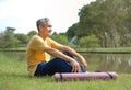 happy senior man in sportswear smiling and sitting in nature Royalty Free Stock Photo