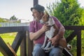 Senior man taking his lovely basenji dog and watching both while sitting on summer veranda