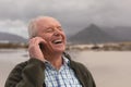 Happy senior man talking on mobile phone at beach Royalty Free Stock Photo