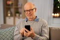 Happy senior man texting on smartphone at home Royalty Free Stock Photo