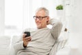 Happy senior man texting on smartphone at home Royalty Free Stock Photo