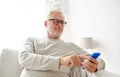 Happy senior man texting on smartphone at home Royalty Free Stock Photo