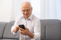 Happy senior man using the mobile phone at home Royalty Free Stock Photo