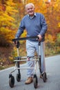 Senior man with a walking disability enjoying a walk in an autumn park Royalty Free Stock Photo
