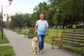 Happy senior man walking Golden Retriever dog in park Royalty Free Stock Photo