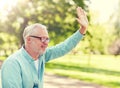 Happy senior man waving hand at summer park Royalty Free Stock Photo