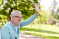 Happy senior man waving hand at summer park Royalty Free Stock Photo