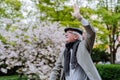 Happy senior man waving to somebody when on walk in park on spring day. Royalty Free Stock Photo