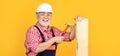 happy senior man woodworker in hard hat on yellow background