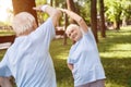 Happy senior mature couple trains together in picturesque city park in summer