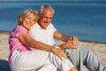 Happy Senior Couple Sitting Laughing on Tropical Beach Royalty Free Stock Photo
