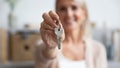 Happy senior woman customer hold key to new house, closeup