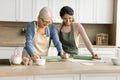 Happy senior mom and adult daughter woman cooking homemade pastry