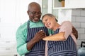 Happy senior multiracial couple enjoying in kitchen at home Royalty Free Stock Photo