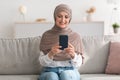 Happy Senior Muslim Woman Using Phone Browsing Internet At Home Royalty Free Stock Photo