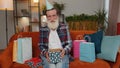 Happy senior old man hold birthday gift box with ribbon, celebrating party, opening present at home Royalty Free Stock Photo