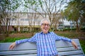 Happy senior old man sitting on a park bench Royalty Free Stock Photo