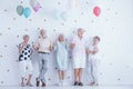 Happy senior people with colorful balloons celebrating friend`s birthday Royalty Free Stock Photo