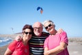 Happy senior people enjoying together the excursion, Summer bright sun at the beach. Wind perfect for windsurf and kite surf. Royalty Free Stock Photo