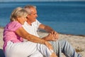 Happy Senior Retired Couple Sitting Smiling on a Beach Royalty Free Stock Photo