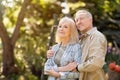 Happy senior retired couple walking at sunny autumn day and enjoying peaceful nature, spending time together outdoors Royalty Free Stock Photo