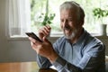 Happy senior 70s aged man using smartphone for video call Royalty Free Stock Photo