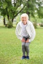 happy senior sportswoman squating on green lawn Royalty Free Stock Photo