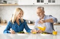Happy Senior Spouses Eating Tasty Breakfast And Drinking Orange Juice In Kitchen Royalty Free Stock Photo