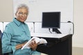 Happy Senior Teacher Holding Book