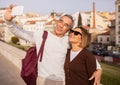 Happy Senior Tourists Couple Making Selfie On Phone Standing Outdoors