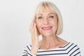 Happy senior woman applying anti-wrinkle eye cream Royalty Free Stock Photo