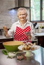 Happy senior woman baking in a bright modern kitchen Royalty Free Stock Photo