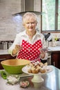 Happy senior woman baking in a bright modern kitchen Royalty Free Stock Photo