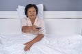 Senior woman in bed with remote control and watching tv Royalty Free Stock Photo