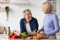 Happy senior woman cooking for her husband Royalty Free Stock Photo