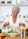 Happy senior woman cooking a salad Royalty Free Stock Photo