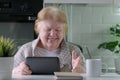 Happy senior woman with digital tablet having video call at home Royalty Free Stock Photo